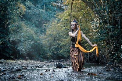 Portrait of woman standing in forest