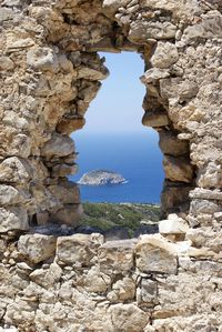 Rock formations by sea against sky