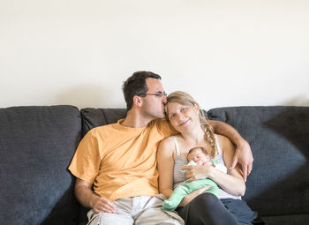 Friends sitting on sofa at home