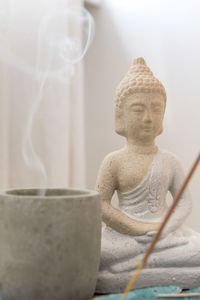 Soothing atmosphere with buddha statuette and smoking candle