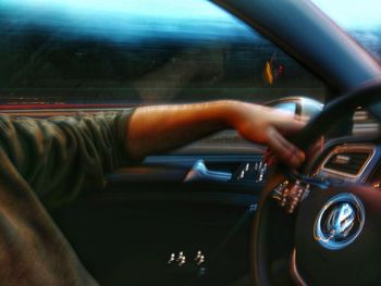 Close-up of hand on car windshield