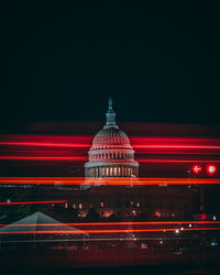 Red light trails against government building at night