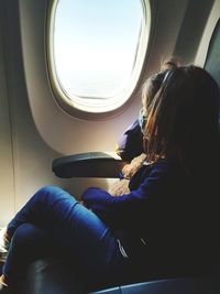 Midsection of woman sitting in airplane