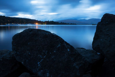 Scenic view of lake by mountains against sky