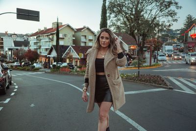 Portrait of woman standing on road in city