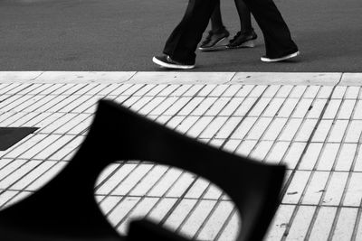 Low section of man standing on footpath