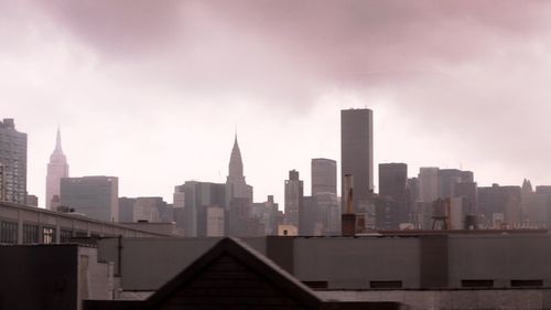 View of buildings in city against cloudy sky