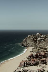 High angle view of sea and buildings against clear sky