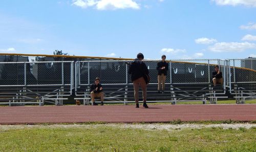 Men at playing field against sky