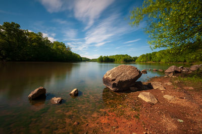 Rocks in lake against sky