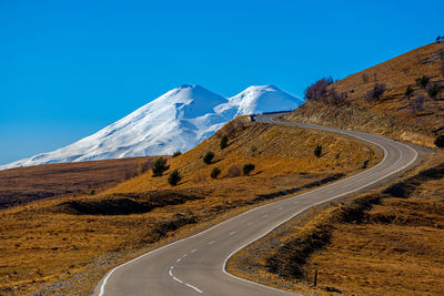 Scenic view of snowcapped mountains against clear blue sky