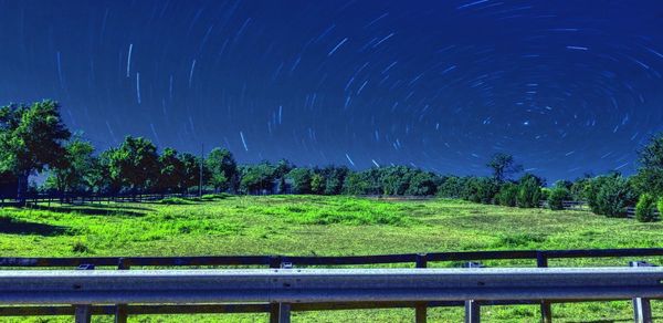 Scenic view of green landscape against sky at night