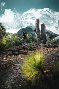 Man standing by tree against sky