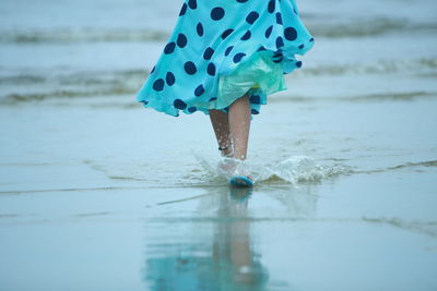 Low section of woman standing on beach