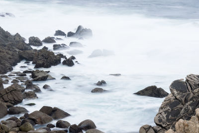 Scenic view of rocks in sea against sky