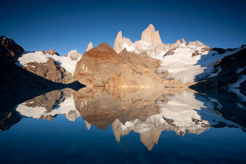 Scenic view of lake by mountains against clear sky