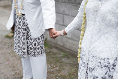 Midsection of couple holding hands