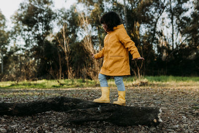 Full length of girl walking on fallen tree