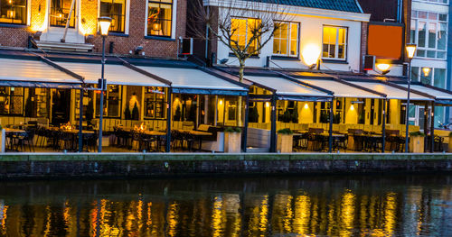 Buildings by river at night