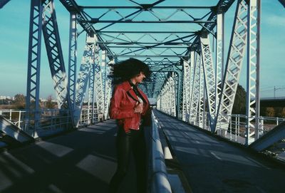 Woman standing on bridge in city