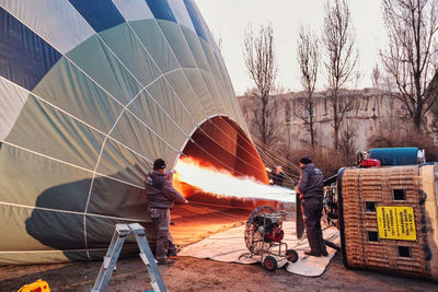 Reflection of people on hot air balloon against sky