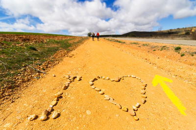 Man walking on sand against sky