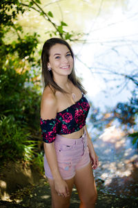 High angle portrait of smiling teenage girl standing against lake