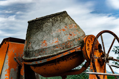 Low angle view of old cement tool against sky