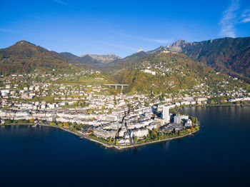 Scenic view of lake and buildings against blue sky