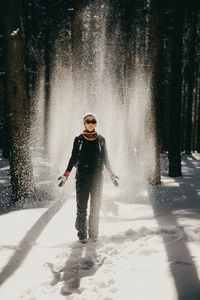 Full length of smiling woman in snow during winter