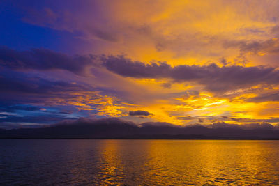 Scenic view of sea against dramatic sky during sunset