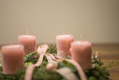 Close-up of candles and wreath on table during christmas