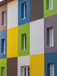 Facade of a house divided into rectangular spaces colored different ways.