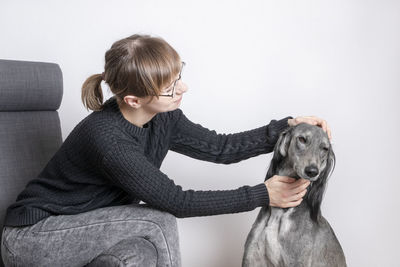 Woman with dog sitting at home