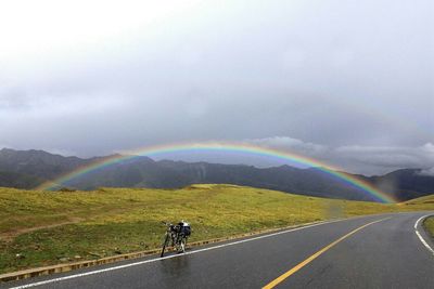 Scenic view of mountain road against storm clouds