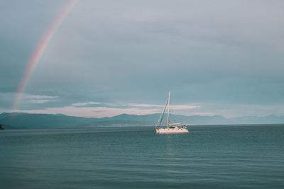 View of rainbow over sea and boat