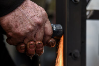 Cropped hand of man repairing car