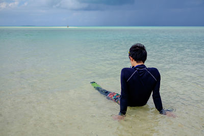 Rear view of woman standing on beach