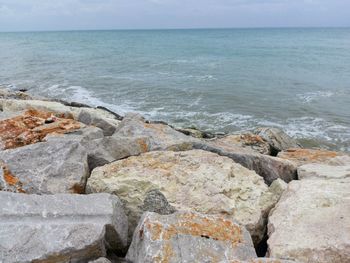 Rocks on beach against sky