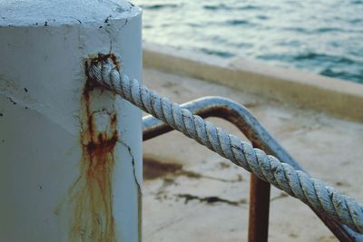 Close-up of rope by pole at beach