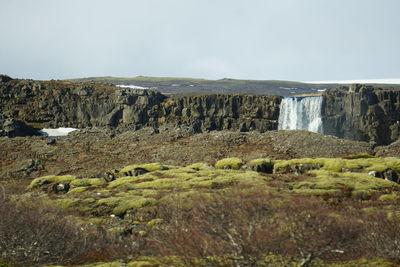 Scenic view of waterfall against sky