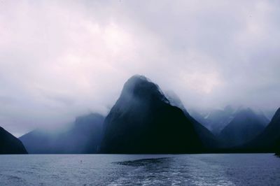 Scenic view of sea and mountains against sky