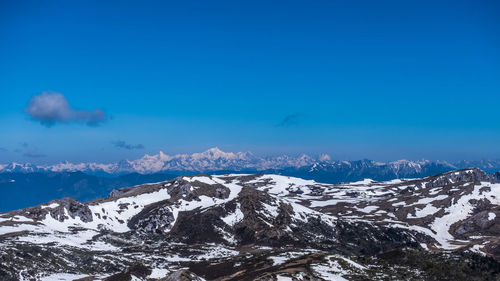 Scenic view of snowcapped mountains against blue sky