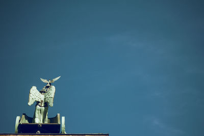 Low angle view of statue against blue sky