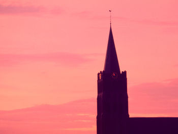 Silhouette of building against orange sky