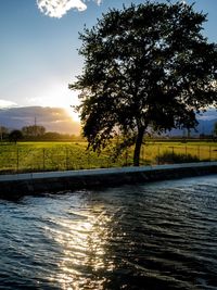 Scenic view of river against sky at sunset