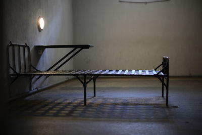 Empty chairs and table against wall