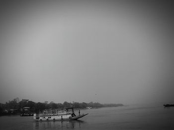 Boat sailing in sea against clear sky