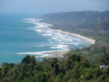 Scenic view of sea and mountains against sky