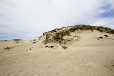 Sand dunes in desert against sky